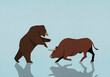 © fStop - Bull and bear stock market symbols fighting on blue background