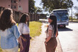 Grupo multiracial de mulheres conversando no ponto de onibus.
