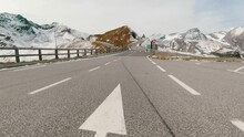Car ride Point Of View, The Majestic Grossglockner Mountain Road in Austria, snow covered sharp peaks of the alpine mountains. POV shot of sport car or bicycle drives along the majestic and most