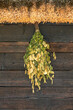 A birch broom for a bath hangs on the wall under the roof.