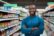 © vasyan_23 - a happy african american man seller consultant on the background of shelves with products in the store