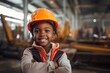 Happy african american child boy in an engineer hard hat at a construction site. Work process, construction of a house