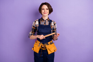 Sticker - Photo of young woman builder craftsman hold hammer tools repair restoration isolated over violet color background