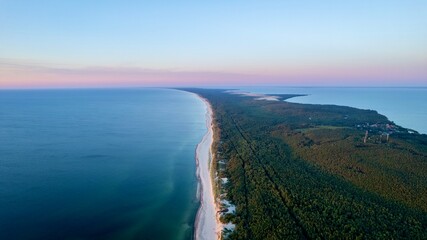 Curonian Spit National Park at sunset, aerial shot. A narrow and long sandy strip of land separating the Curonian Lagoon from the Baltic Sea. Forest and sea. Drone view