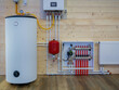 © Grispb - Heating boiler tank. Room with heating equipment. Gas boiler technologies. Heating system country house. Boiler tank at wooden wall. Gas equipment to maintain temperature. Engineering communications