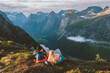Couple in sleeping bags bivouac in mountains camping travel gear friends hiking in Norway, romantic vacations outdoor man and woman together family active healthy lifestyle