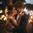 bride and groom in front of a nighttime lights and sparklers