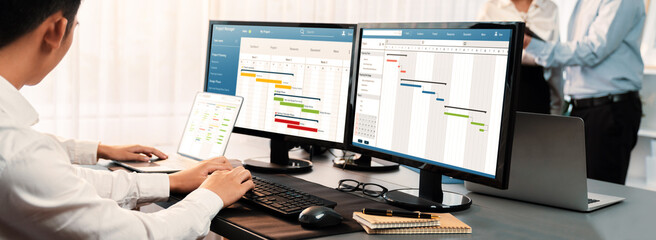 Project management team coordinating and update project planned schedule on computer using Gantt chart software in office. Business people planning time and deadline for company task. Trailblazing