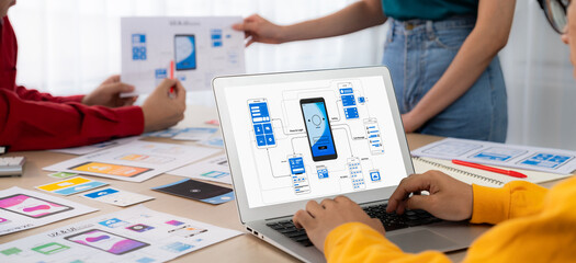 Panorama banner of startup UX developer or company employee design user interface or UI prototype for mobile application or website software with software display on laptop monitor in office. Synergic