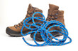 trekking boots for hiking next to a climbing rope on a white background. Travel and Hiking Equipment