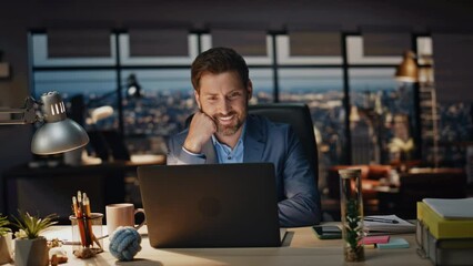 Wall Mural - Happy manager reading computer in dark office closeup. Smiling man overworking