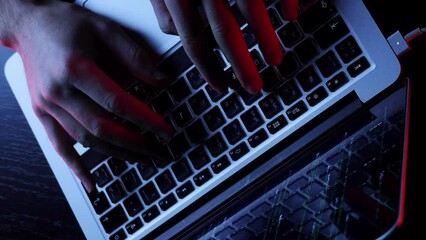 Developer working in dark office writing program code on laptop. Vertical video