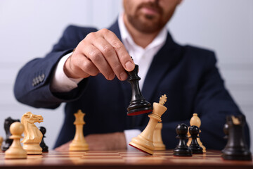 Poster - Man with king game piece playing chess at checkerboard, closeup