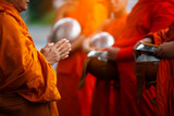 Fototapeta  - Buddhist monk holding alms bowl waitting for buddhism make merit by offering food and water at morning