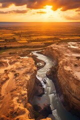 Wall Mural - A picturesque scene of the sun setting over a beautiful canyon with a river flowing through it. Perfect for nature lovers and travel enthusiasts.