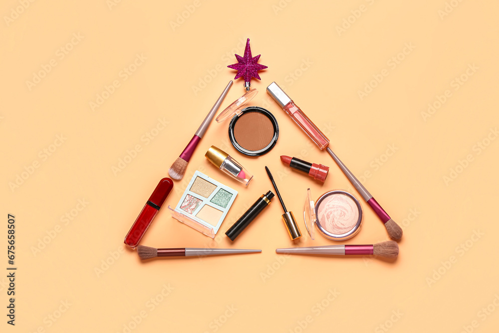 Christmas tree made of makeup products and decor on orange background
