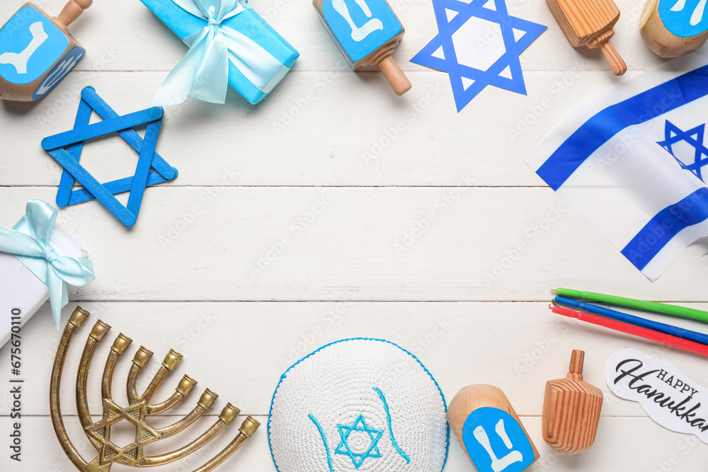 Festive frame made from Hanukkah symbols on white wooden background