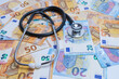 man holding a stethoscope with euro banknotes in the background, health care costs concept