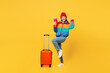 © ViDi Studio - Traveler woman wearing padded windbreaker jacket red hat hold passport ticket bag isolated on plain yellow background. Tourist travel abroad in free time rest getaway. Air flight trip journey concept.