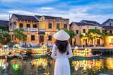 Fototapeta Most - Asian woman wearing vietnam culture traditional at Hoi An ancient town, Vietnam. Hoi An is one of the most popular destinations in Vietnam  from Korea, Thailand, USA, Japan, China