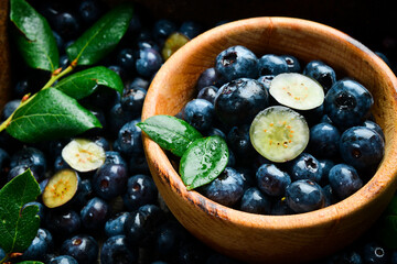 Wall Mural - A bowl of blueberries. Fresh berries and leaves. Vitamins and berries. Top view.