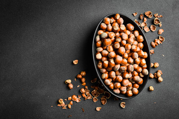 Wall Mural - Nuts background. Hazelnuts in a black oval bowl. Healthy Eating. Close up.