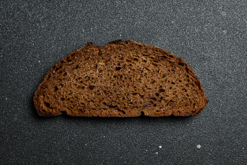 Wall Mural - A piece of fresh black wheat sourdough bread. Top view.