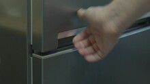 A Man's Hand Opens And Closes The Doors Of A Gray Refrigerator
