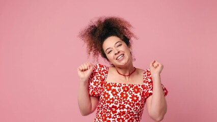 Poster - Excited jubilant overjoyed happy young latin woman wear red casual clothes do winner gesture celebrate clench fists say yes isolated on plain light pink background studio portrait. Lifestyle concept