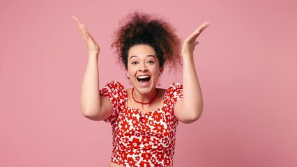 Poster - Young latin woman wear red casual clothes look camera surprised ask what wow omg no way doing winner gesture say yes celebrating put hands on face isolated on pastel plain light pink background studio