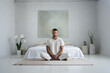 Man meditating in bedroom
