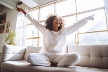 Happy Afro American Woman Relaxing On The Sofa At Home. Smiling Girl Enjoying Day Off Lying On The Couch. Healthy Life Style, Good Vibes People And New Home Concept.