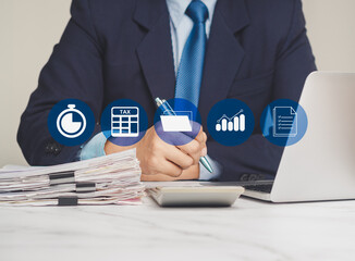 Businessman filling out tax filing paperwork while sitting at the table in the office.