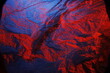 Bollo de papel tissue  absorbente y arrugado para la higiene de manos y limpieza del hogar   iluminado con luz roja y azul, forma una superficie texturizada abstracta para fondos