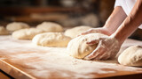 Fototapeta  - baker kneading dough in bakery