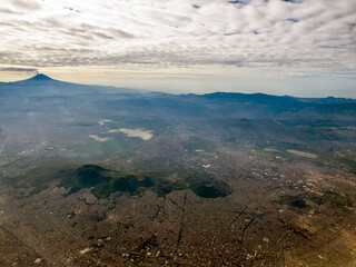 Wall Mural - Smoking Popocatepetl volcano in Mexico aerial view with Tetlalmanche volcano