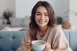 © Areerat - Close up of a young woman holding coffee cup in the morning sitting on sofa white background.