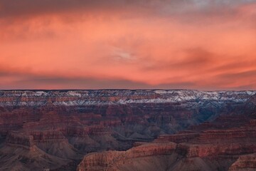 Stunning landscape featuring two white clouds in a vibrant blue sky over a dramatic, dry cliff