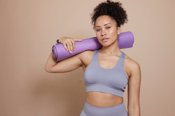 Wall Mural - Studio portrait of athletic woman with yoga mat