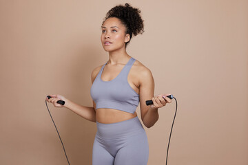 Wall Mural - Studio portrait of athletic woman jumping rope