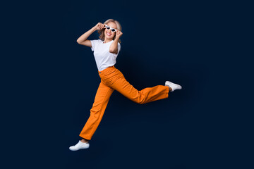 Wall Mural - Full length photo of optimistic glad girl in stylish outfit going store mall isolated on dark blue color background