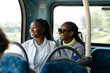 Young female friends riding city bus