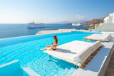 Fototapeta  - Tourist enjoys at infinity pool with sea view, Mykonos, Greece