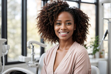 Happy African-American woman with a perfect smile and white teeth in a dental clinic
