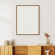 close up of picture frame mock up above wooden cupboard with decor on white wall with sunlight, 3d