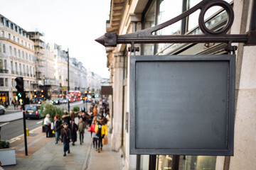 Wall Mural - Blank sign with copy space and defocussed anonymous people on shopping street in the background