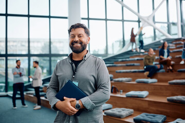 Happy businessman attending education event at convention center and looking at camera.