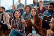 © Drazen - Young happy businesswoman talks on microphone while attending education event in conference hall.