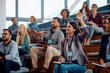 © Drazen - Female entrepreneur raising hand to ask question while attending business seminar.