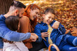 © Mediteraneo - Parents tickle their children. Sunny autumn day in the colorful park